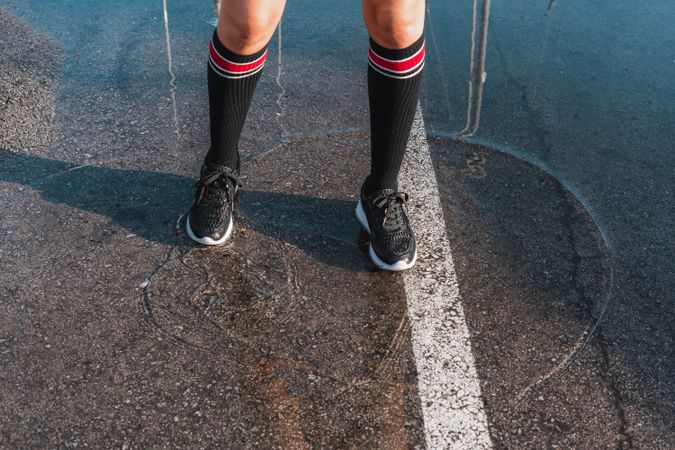 Woman in knee socks and shoes standing in puddles