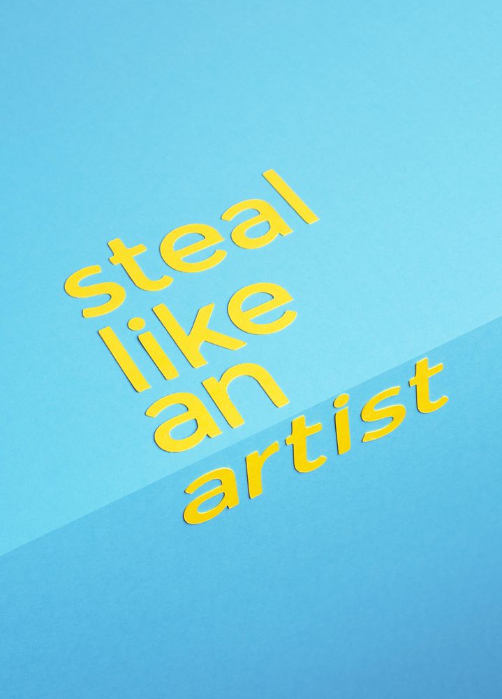 Steal like an artist quote made of paper over blue background