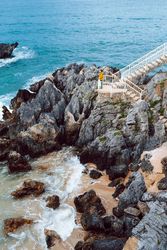 Woman looking at waving sea from steps
