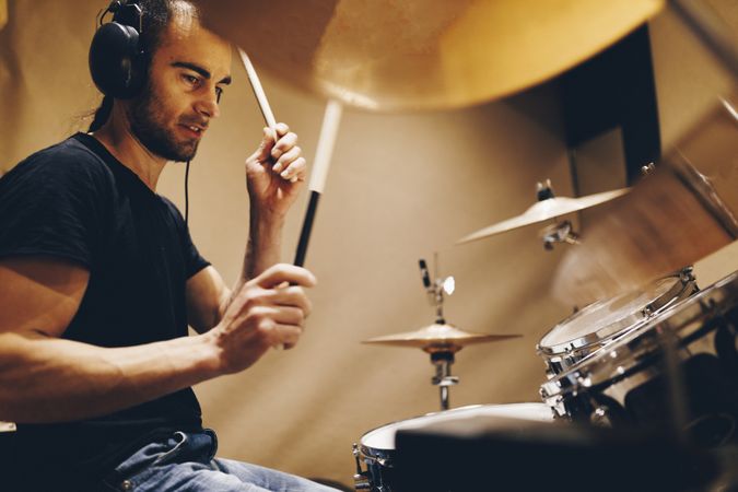 Man with headphones playing on drums
