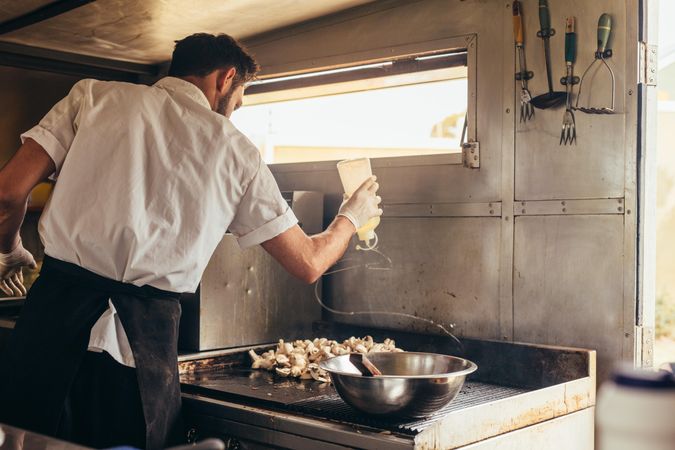 Man preparing food on stove in his food truck