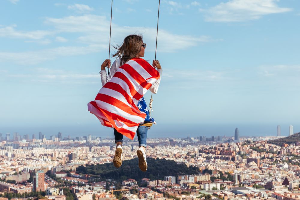 Young woman on swing with USA flag