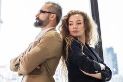 Two business people standing back to back