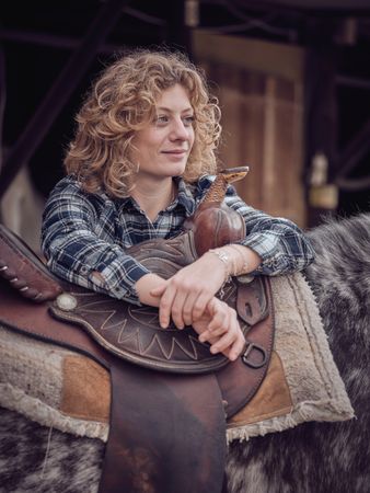 Woman near horse with saddle