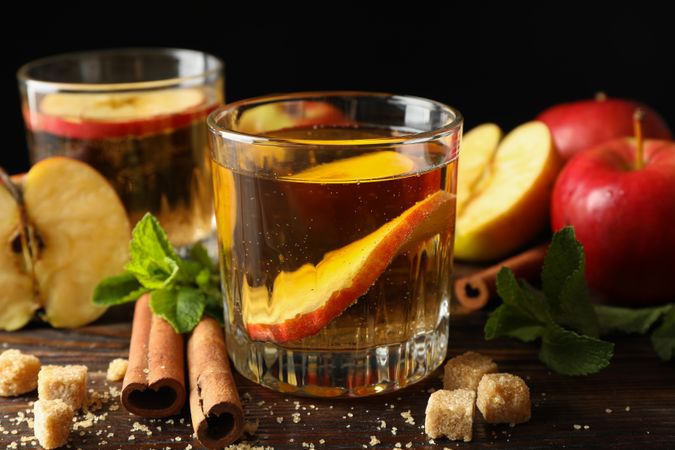 Composition with cider, sugar, cinnamon and apples on wooden table