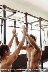 Fit couple high five after workout in health club 0y3on4