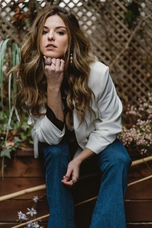 Woman sitting on planter in garden