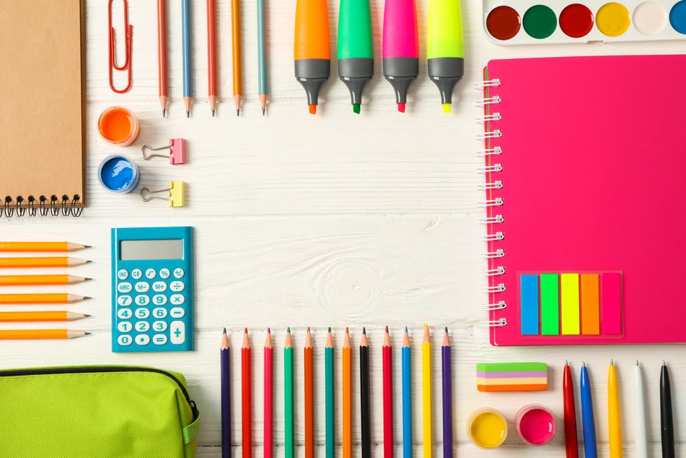 Flat lay composition with school supplies on wooden background, space for text
