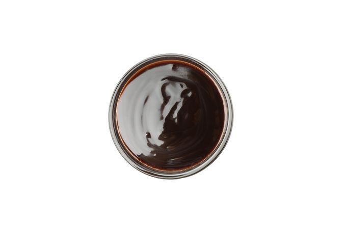 Bowl with melted chocolate isolated on neutral background