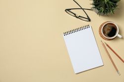 Office concept with blank notebook on beige background, space for text