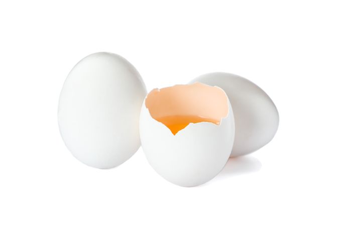 Chicken eggs and half yolk isolated on blank background