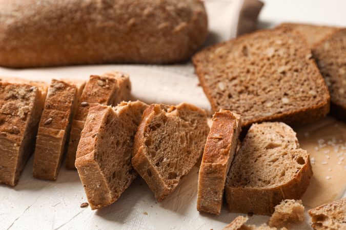 Composition with bakery products, salt and kitchen towel on neutral background, closeup and space for text