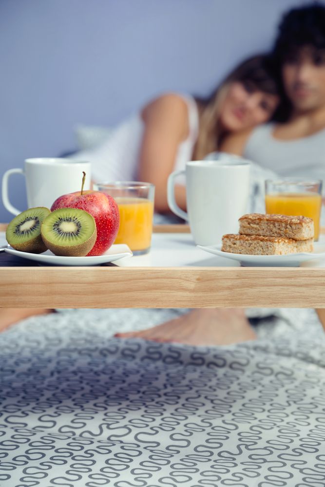 Healthy breakfast on tray and couple blurred in background