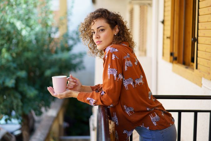 Woman enjoying coffee on balcony in the morning