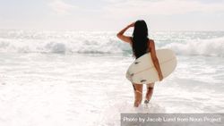 Slender surfer holding surfboard looking out for waves 5kE6Wb