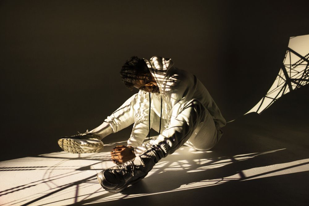 Black man dancing under bright light