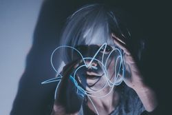Portrait of woman holding blue led light thread
