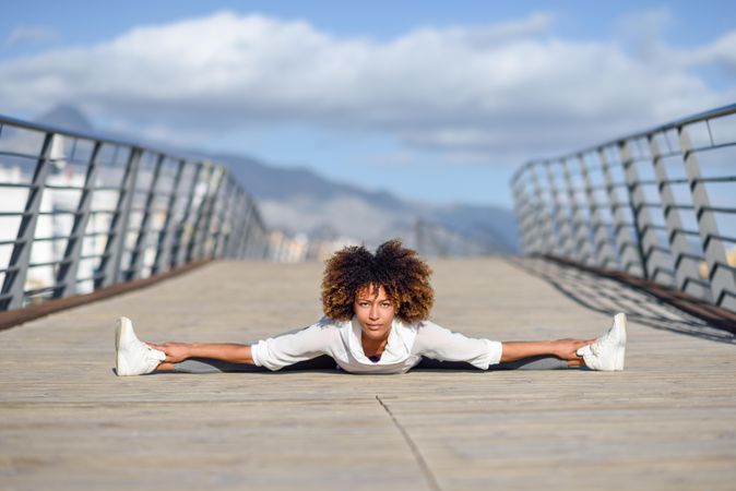 Woman leaning into side splits on bridge