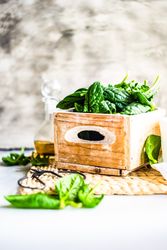 Box of spinach leaves on rattan placemat