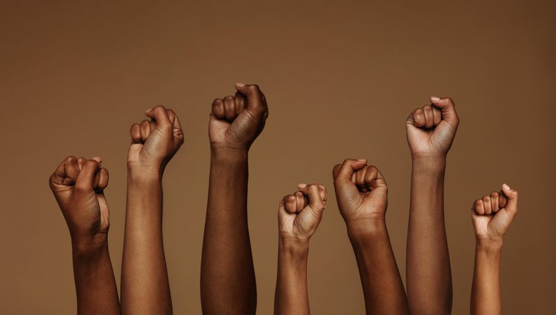 Cropped shot of hands raised with closed fists