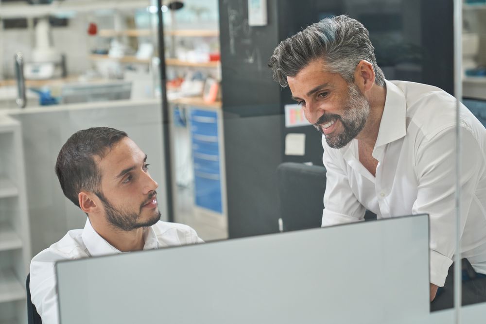 Positive workers working on computer in office
