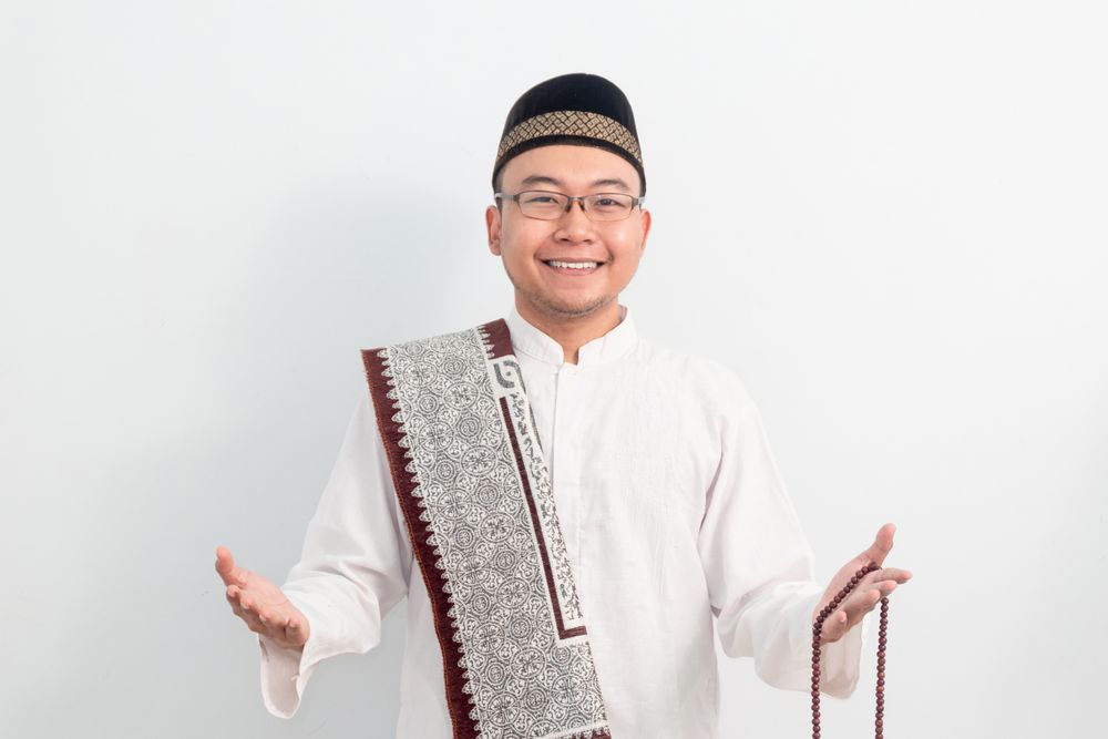 Asian Muslim man smiling doing greeting pose during Ramadan