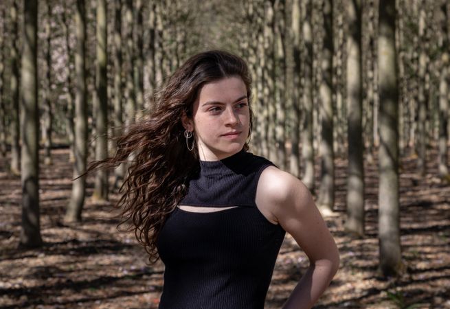 Sporty teenage girl standing in forest