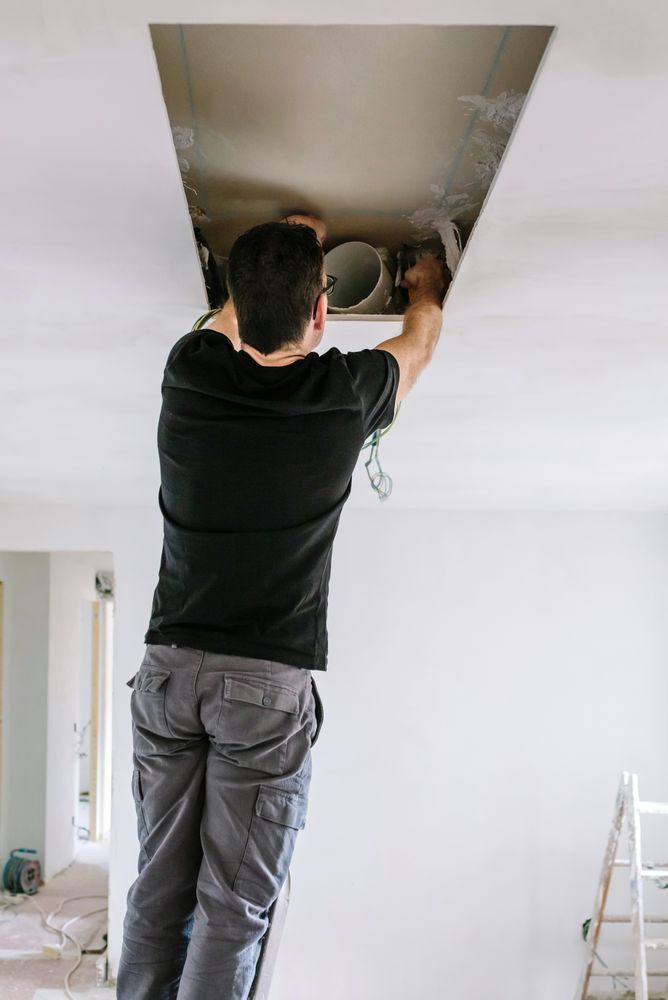 Man preparing extractor hood installation on kitchen ceiling