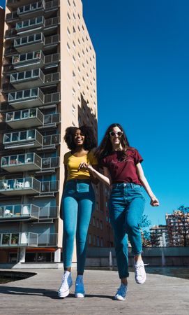 Two females skipping in town