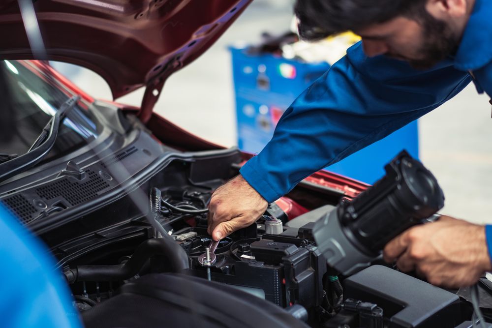 Mechanic working on engine in shop