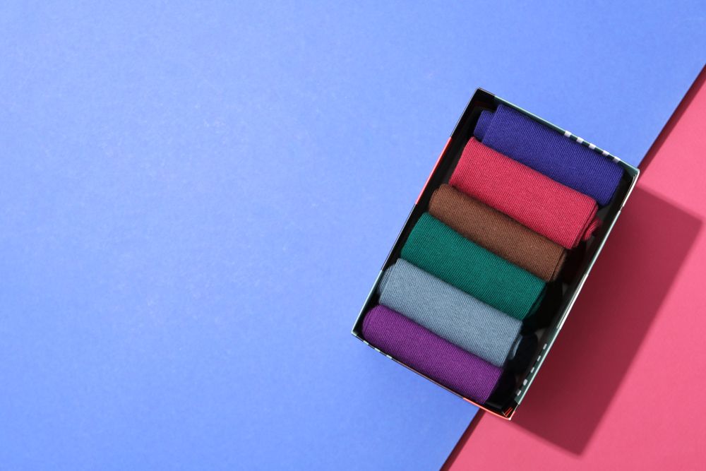 Box with socks on two tone background