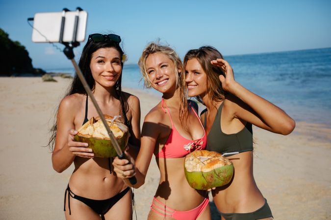 Group of female friends taking selfie on the sea shore