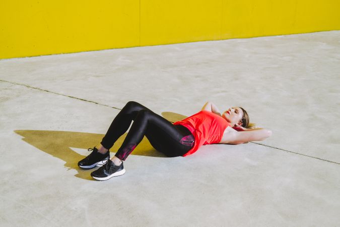 Woman doing sit ups exercises on floor
