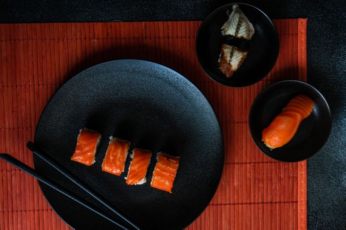 Sushi Set sashimi and sushi rolls served on dark stone slate
