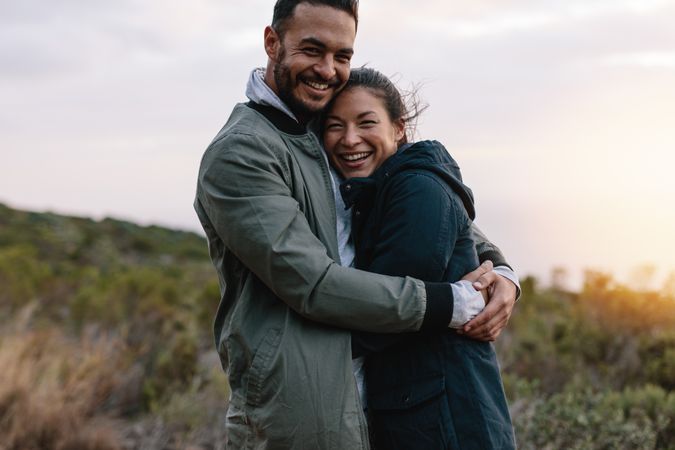 Smiling couple in love embracing in nature