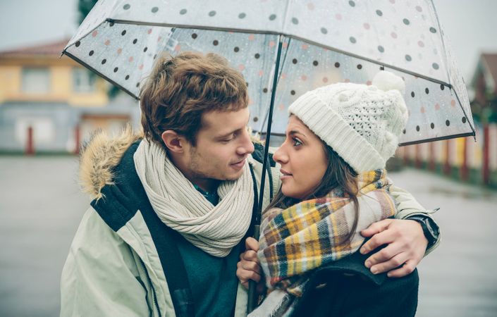Cute couple under umbrella together on cold day