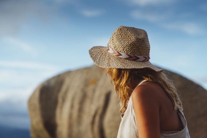 Carefree woman enjoying rest on coast near cliffs
