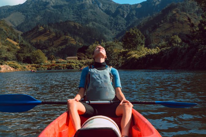 Young female kayaking on nature background