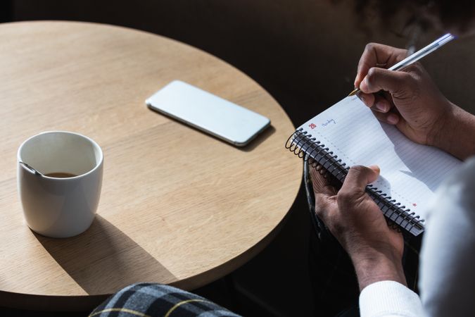 Trendy young Black guy doing assignment in cafe