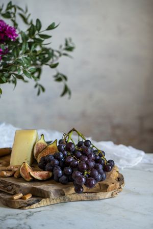 apes next to piece of cheese on cutting boards near pink flowers