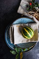 Top view of elegant decorative autumnal table setting with squash and leaves