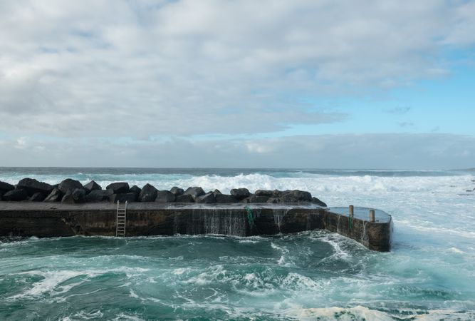 Sea waving near stone pier