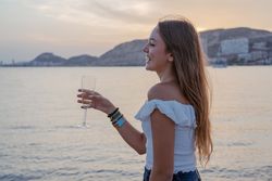 Young woman enjoying wine near sea