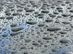 A wet surface with many small drops of water scattered across it