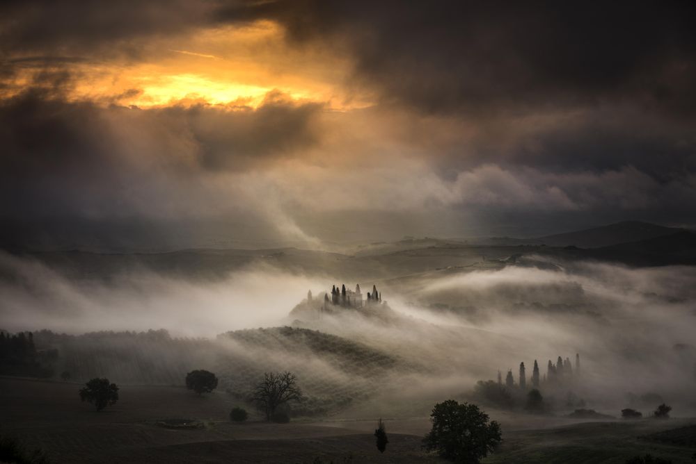Hills covered with fog during sunset