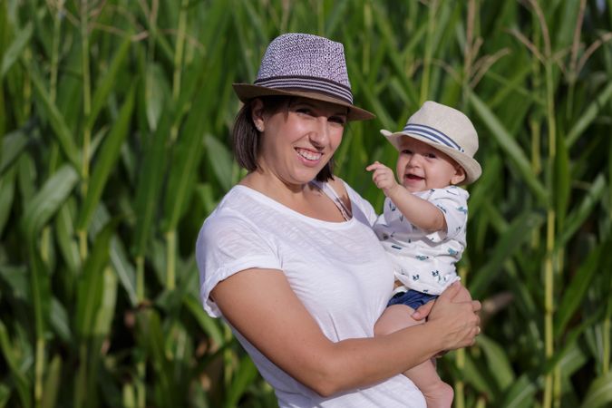 Adorable mother and child on hand enjoying and laughing in field