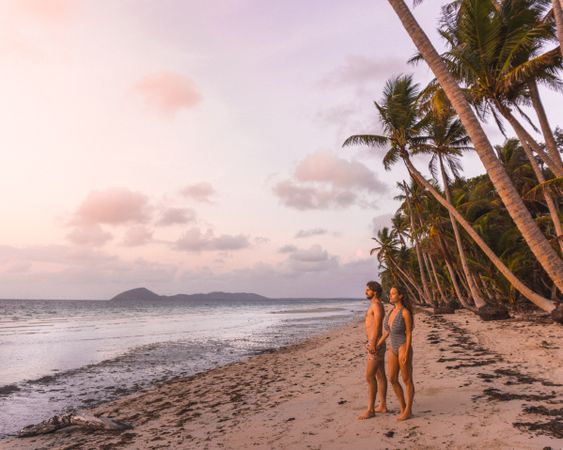 Man and woman in swimsuits standing on seashore