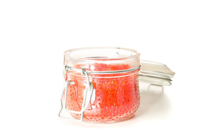 Glass jar with caviar isolated on plain background