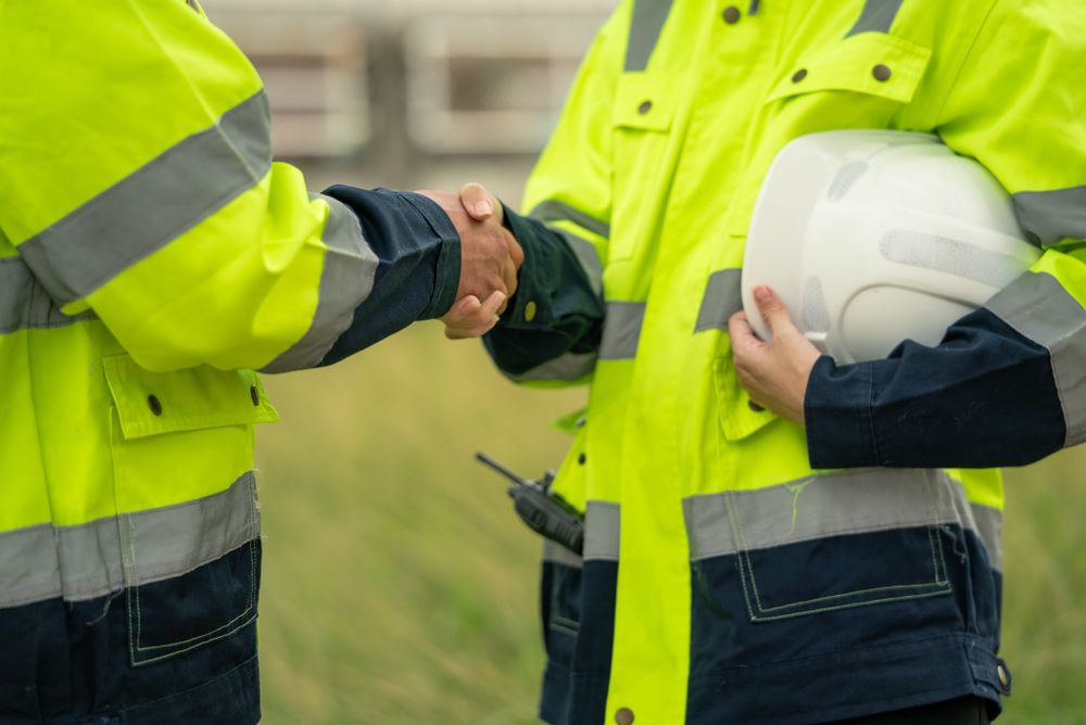 Engineer worker hand shaking to colleagues team for success work