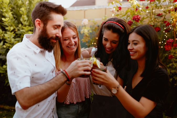 Group of cheerful friends clinking glasses at party